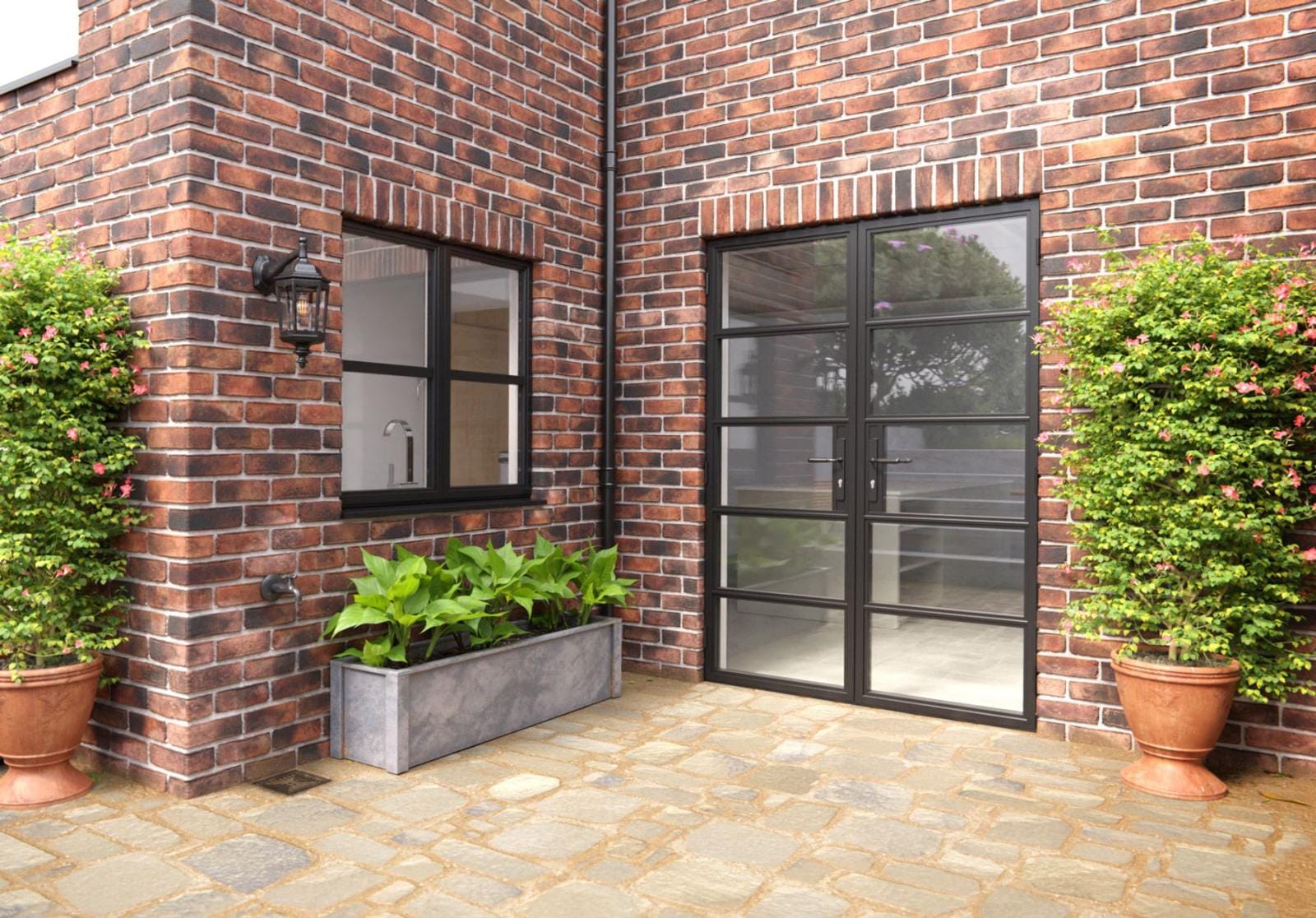 Black steel-look aluminium French doors on a brick house