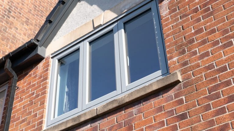 Grey uPVC casement windows on a brick home