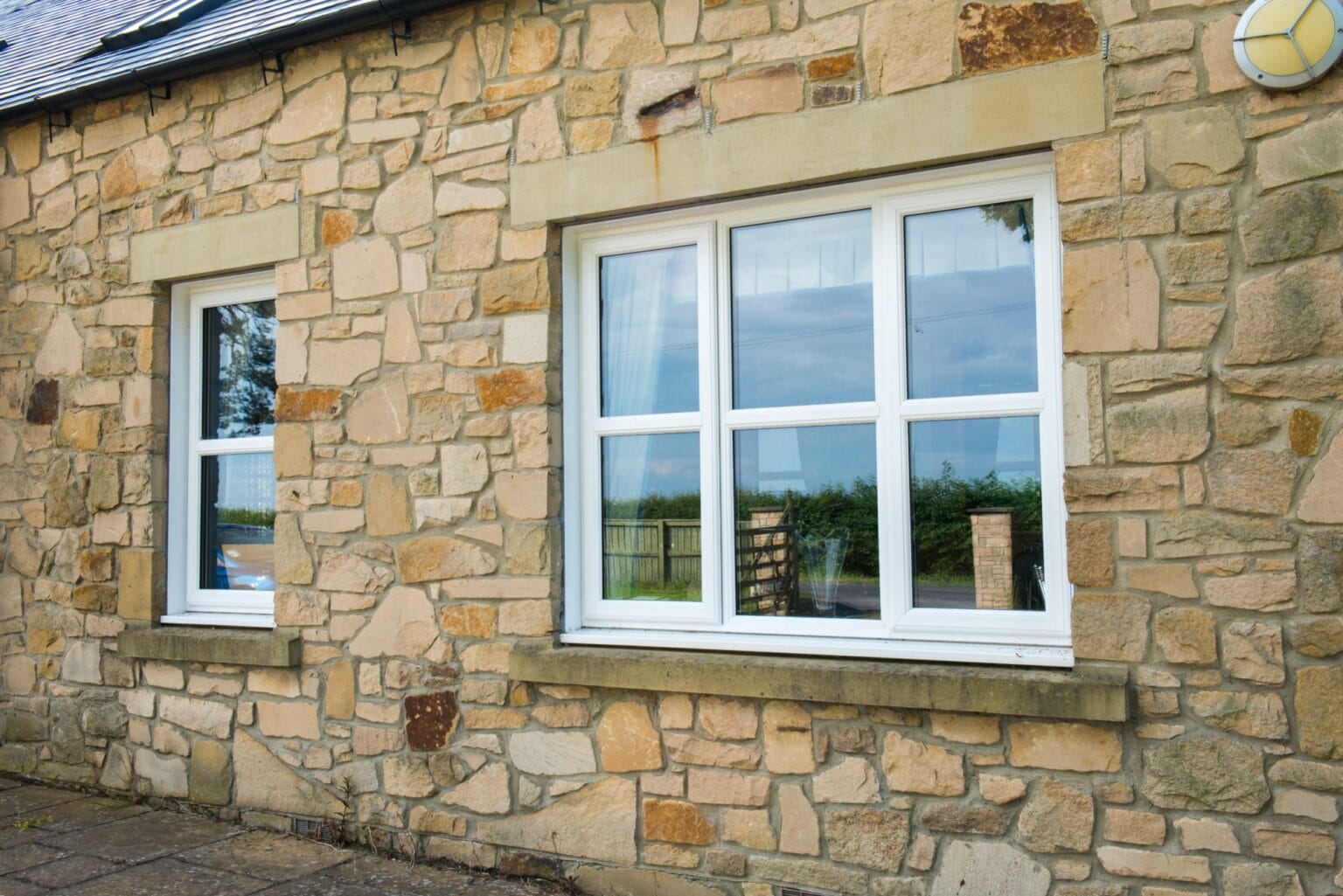 White uPVC casement windows on a stone house