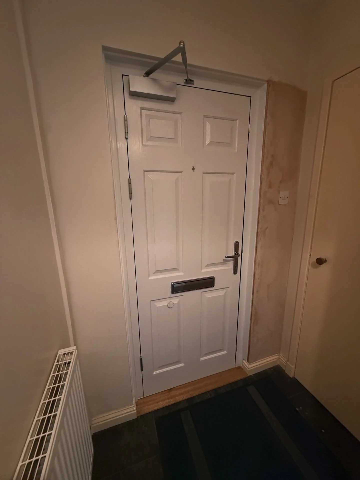 Composite fire door fitted to a flat, inside view showing the overhead self-closer
